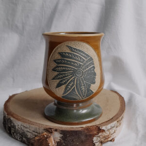 Ceramiczny kielich na nóżce do yerba mate, w kolorze miodowym z rzeźbionym indianinem w kolorze ciemno zielonym.