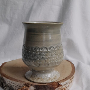 Marmurkowe naczynie do mate w kształcie kielicha na podstawce z wyciskanym wzorem dookoła, w kolorze szaro kremowym .