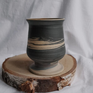 Marmurkowy puchar do yerba mate na podstawce, w kolorze czarno - kremowym z czerwonymi i niebieskimi akcentami.