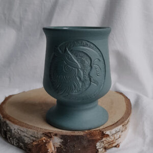 Niebieski ceramiczny kubek do yerba mate, z rzeźbieniem na przodzie, przedstawiającym sowę i księżyc w kole.