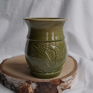 Zielony kubek do mate z rzeźbionym motywem sowy i księżyca umieszczonym w kole.