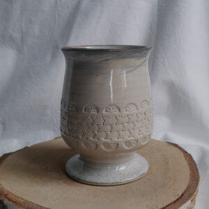 Ceramiczny kielich do mate, w kremowym kolorze i delikatnym marmurkowym akcentem na kołnierzu. Dodatkowym zdobieniem jest wyciskany wzór dookoła naczynka.