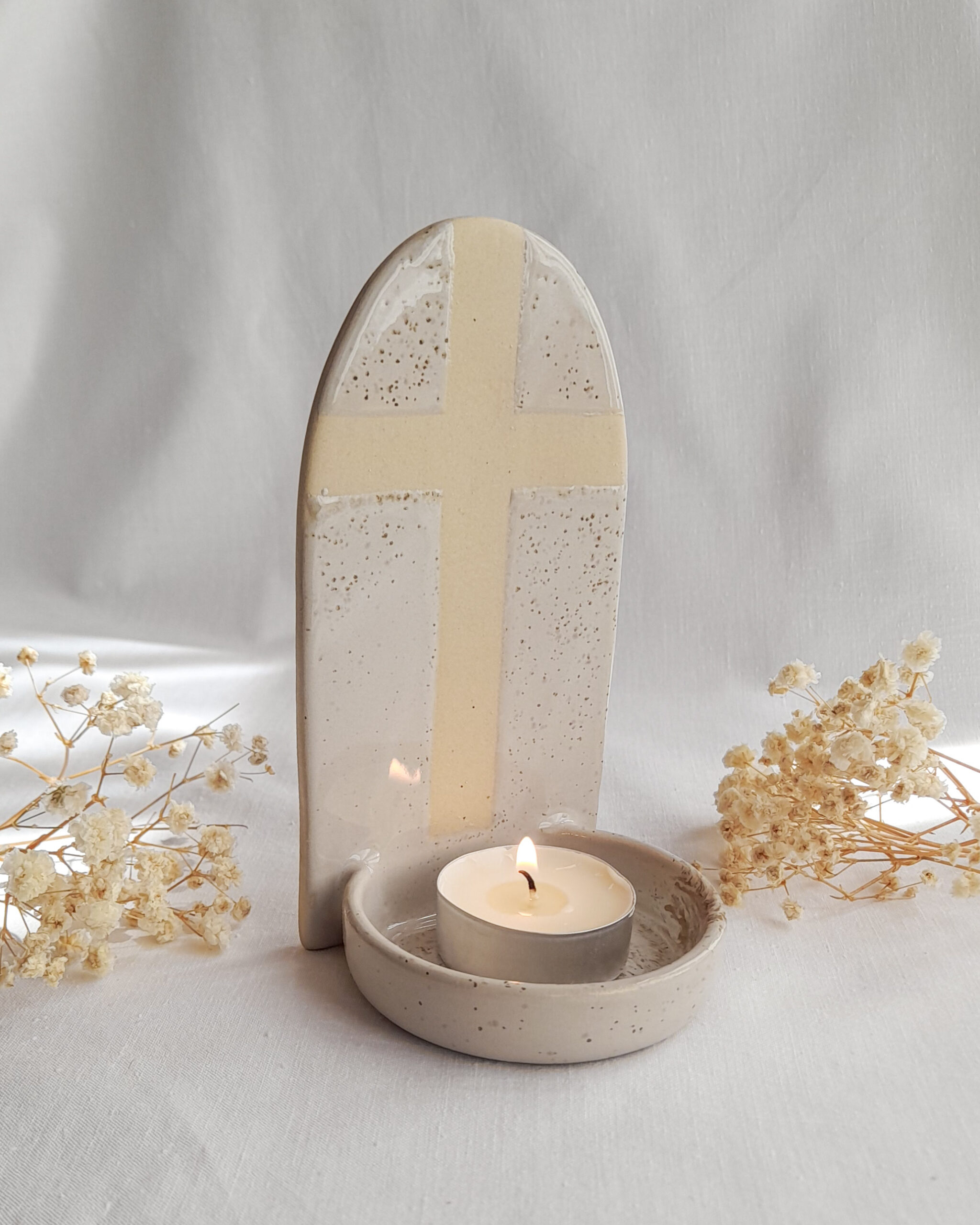 Beżowy świecznik z motywem krzyża i miseczką na świeczkę typu tealight